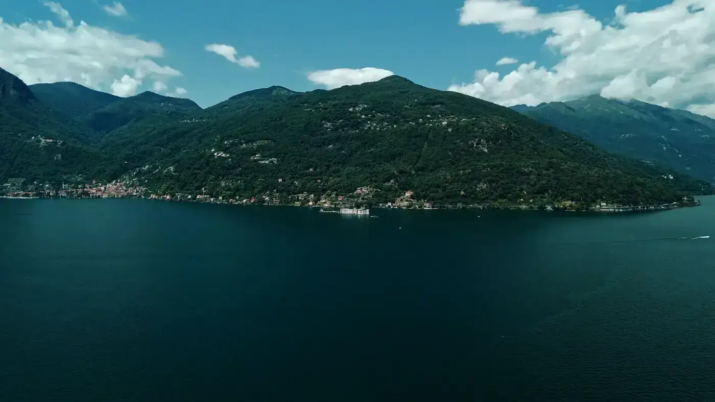 Breathtaking aerial view of Lake Maggiore surrounded by lush greenery and mountains.