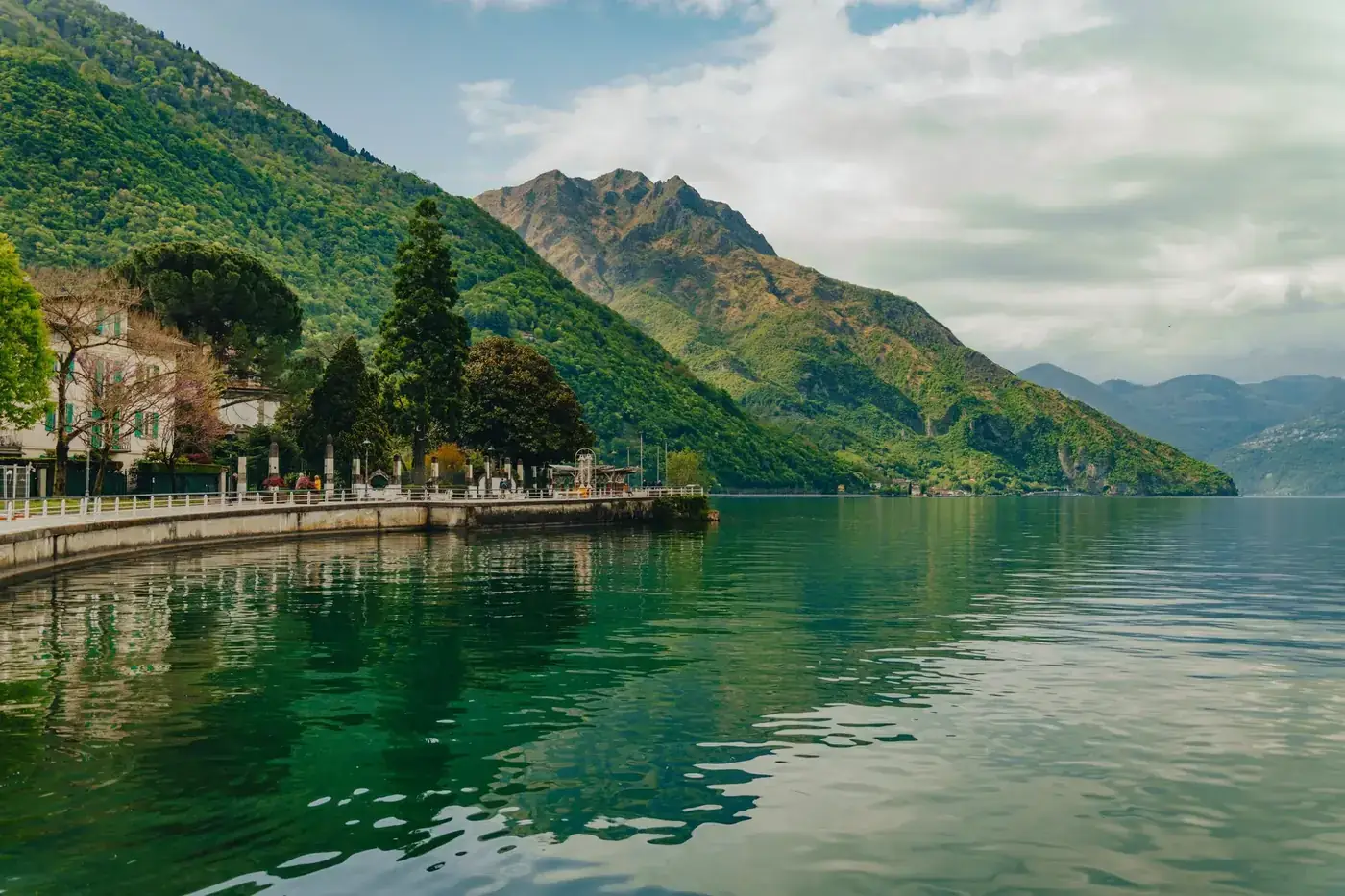 Peaceful view of Iseo Lake with lush green mountains in Lombardy, Italy.