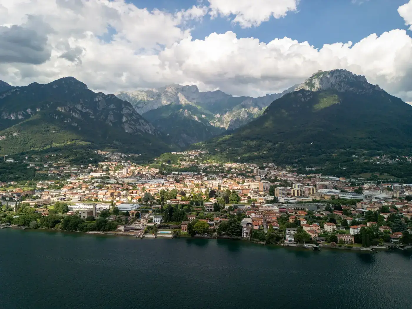 A stunning aerial shot showcasing the breathtaking landscape of an Italian lakeside town surrounded by mountains.
