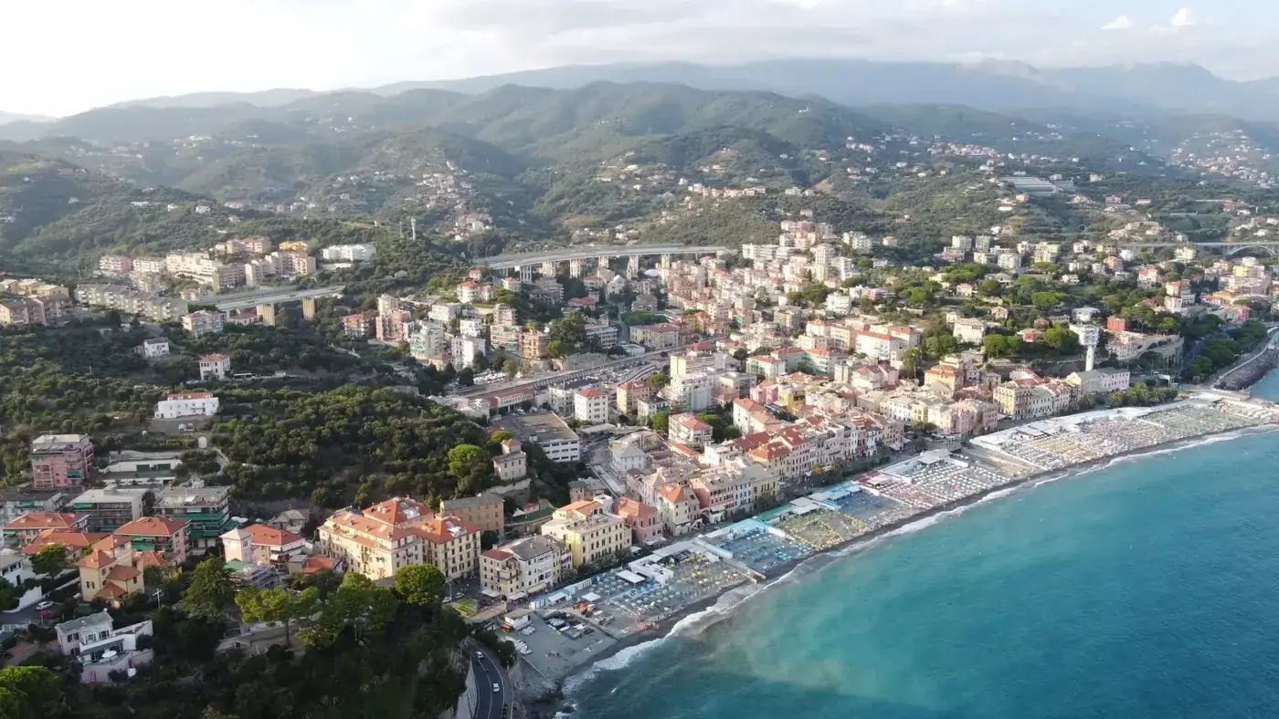 A stunning aerial view of Celle Ligure's scenic coastline with houses and lush green hills.