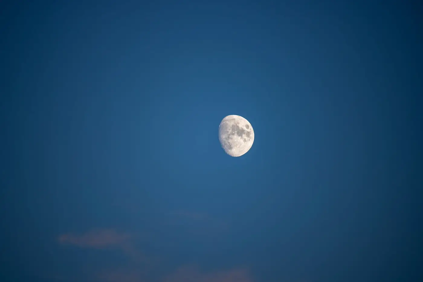 Crisp moon visible against a clear evening sky over Noventa Vicentina, Italy.