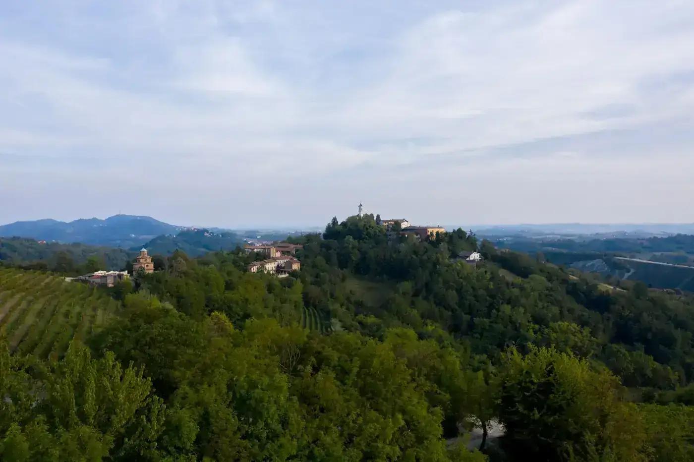 A serene hilltop village surrounded by lush greenery and expansive landscapes.