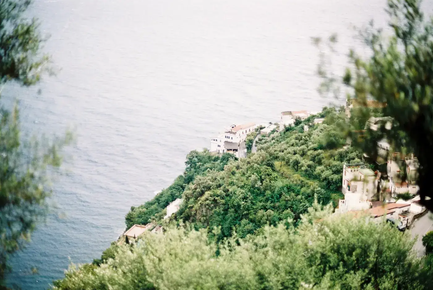 Lush green hills meeting the vast blue Tyrrhenian Sea on the Amalfi Coast, Italy.