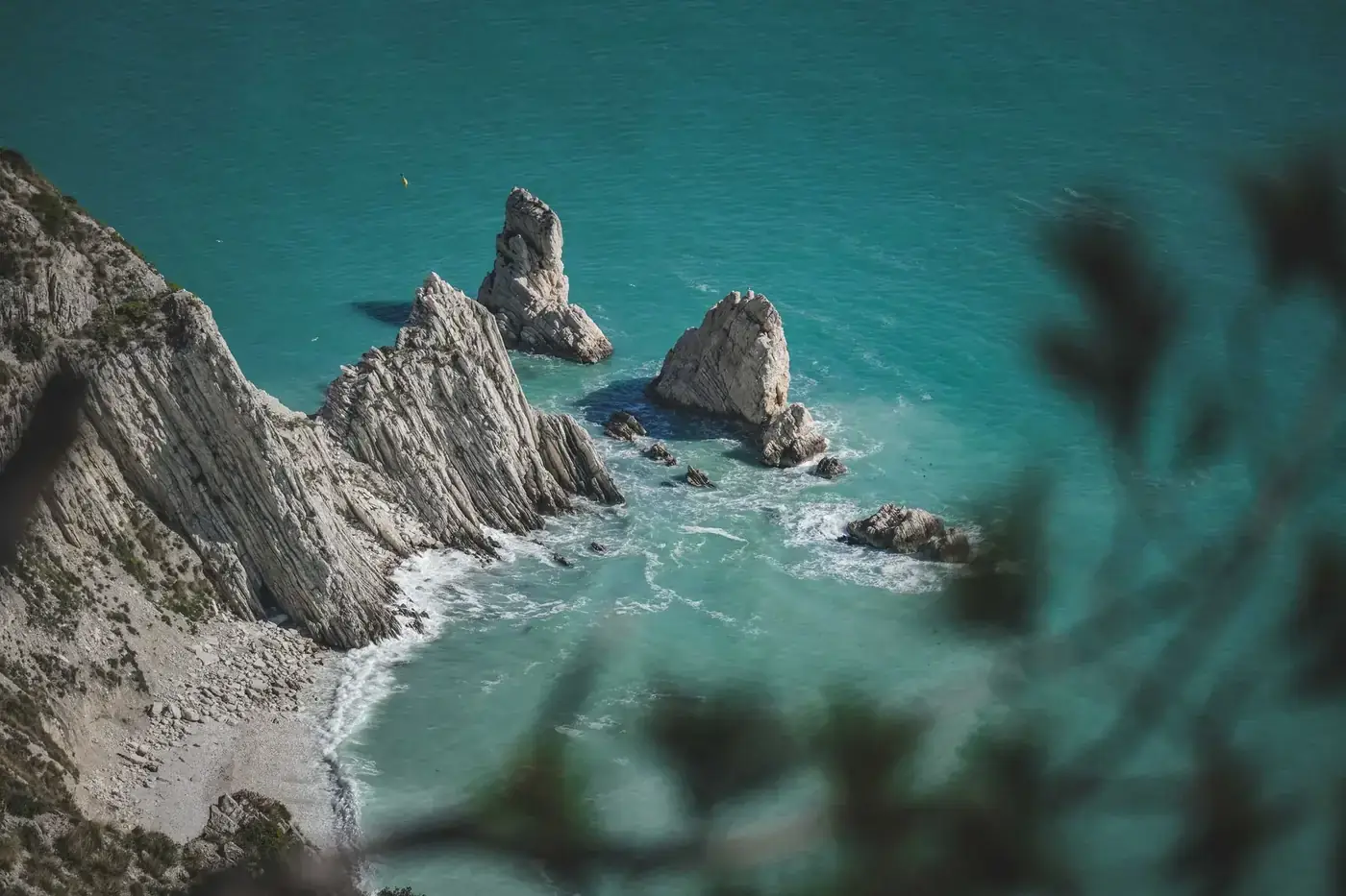 High-angle view of rugged cliffs and clear blue sea, perfect for travel and nature imagery.