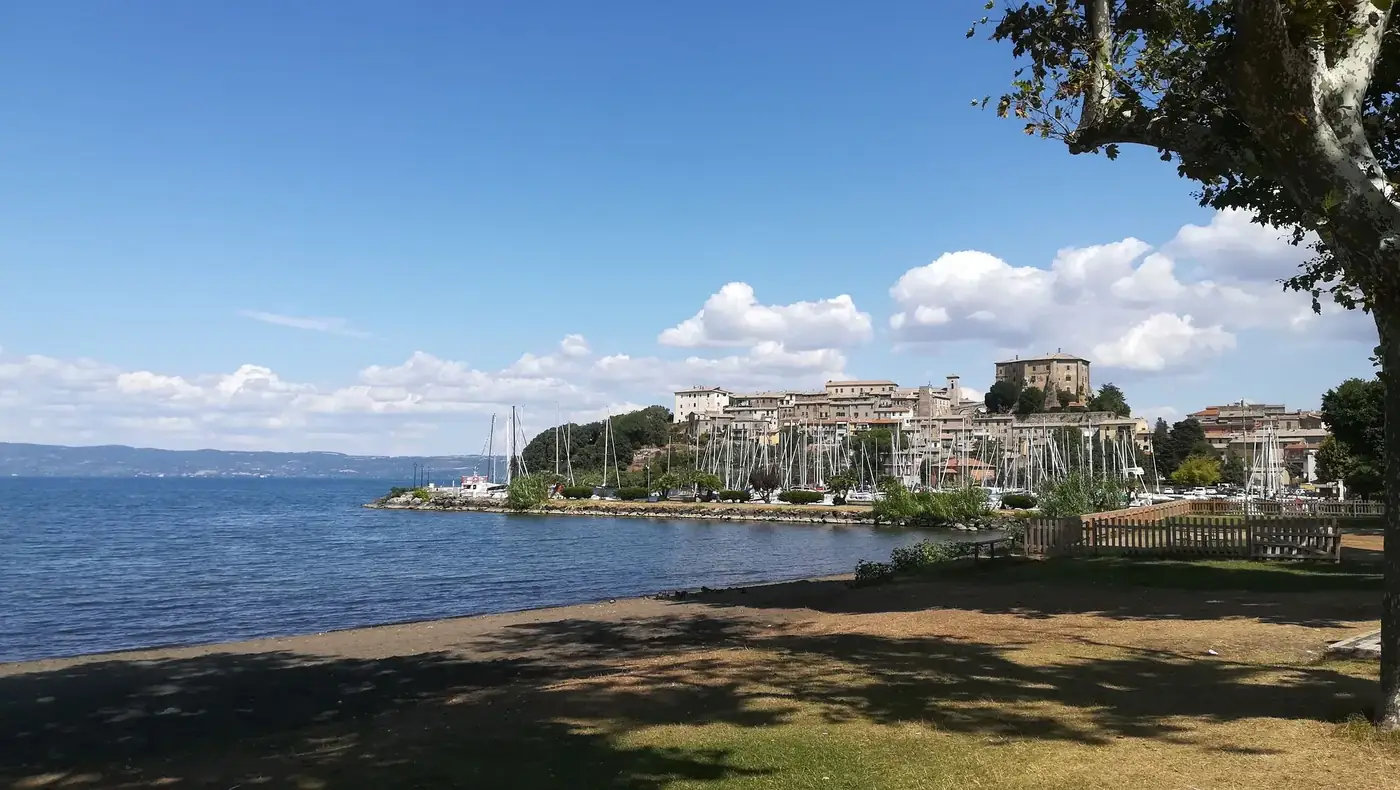 Scenic coastal town with sailboats, blue sky, and lush greenery.