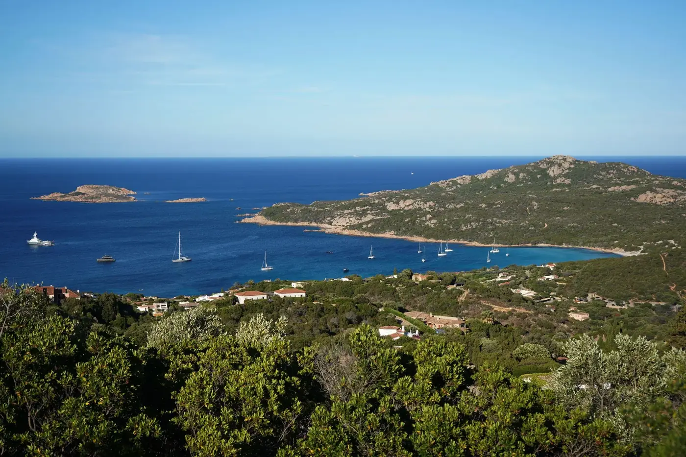 Beautiful panoramic view of Sardinia's coastline with clear blue waters and lush greenery.