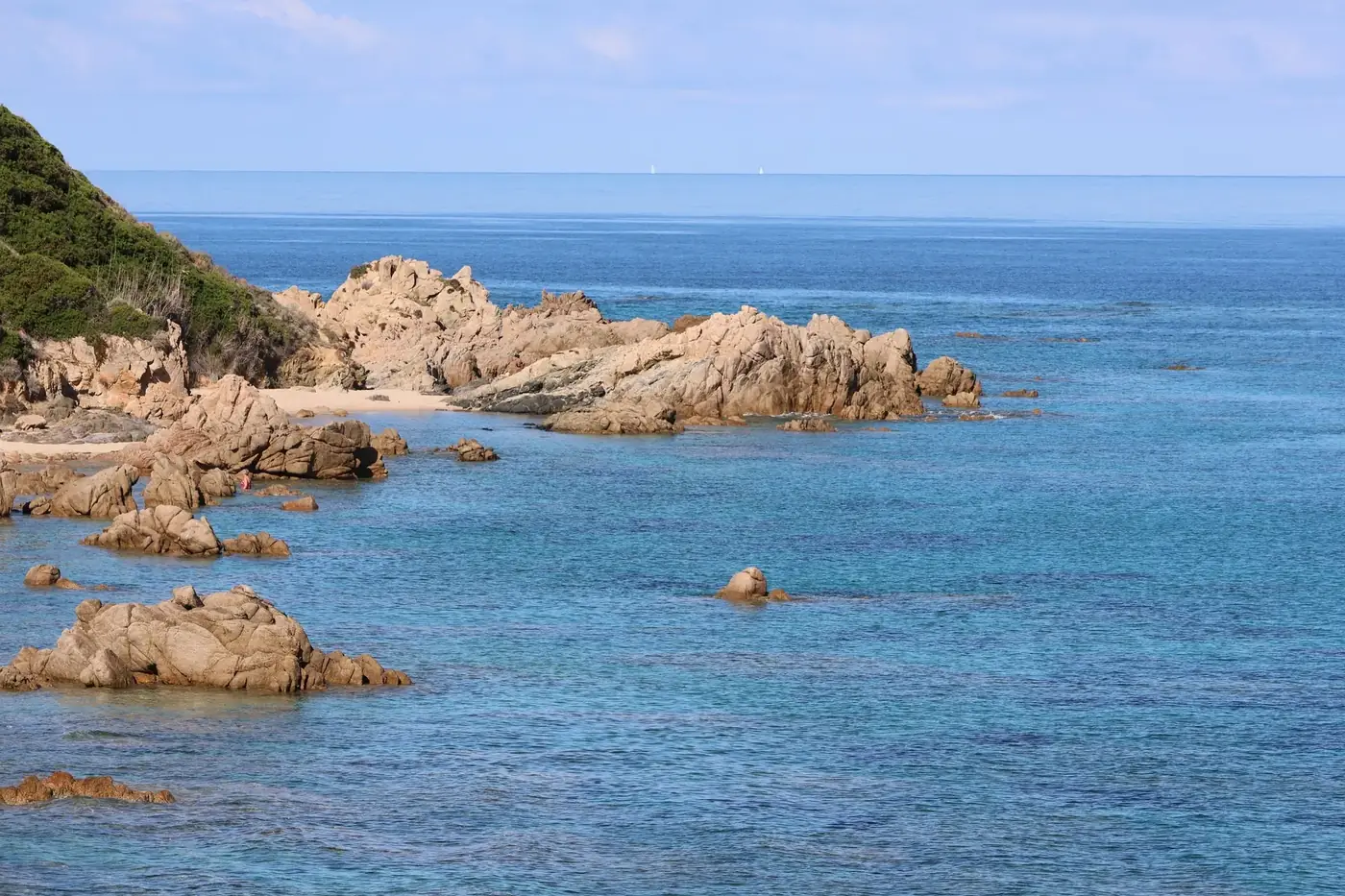 Vibrant coastal scene showcasing rocky shores and azure sea waters under a clear day.