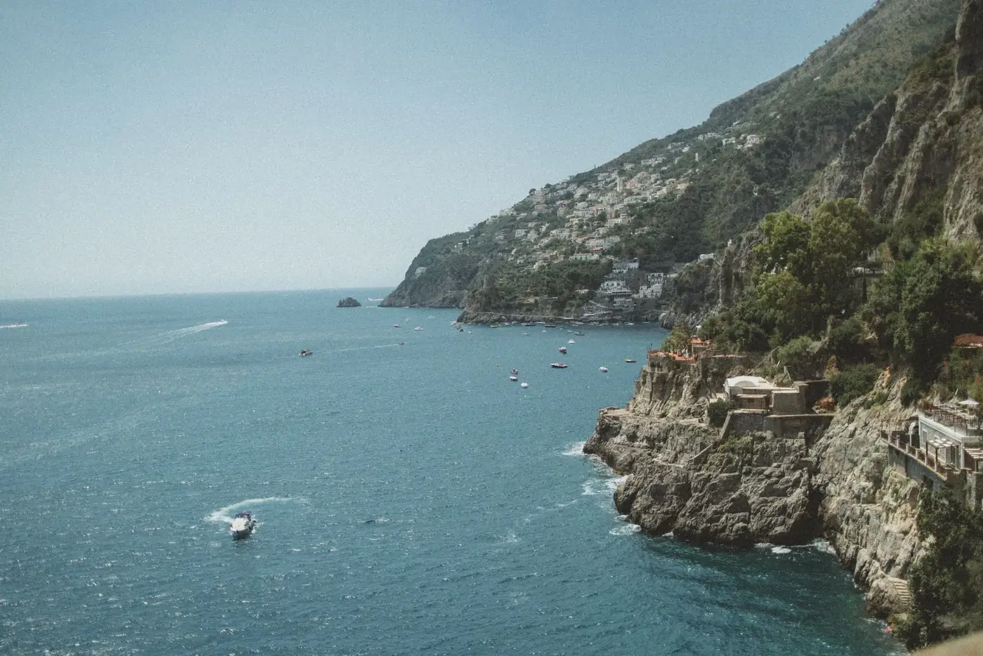 Stunning aerial view of Furore, Italy, showcasing the coastline and Tyrrhenian Sea under a clear blue sky.