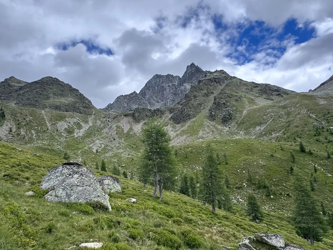 Breathtaking view of lush alpine mountains in Tyrol, Austria, under a partly cloudy sky.