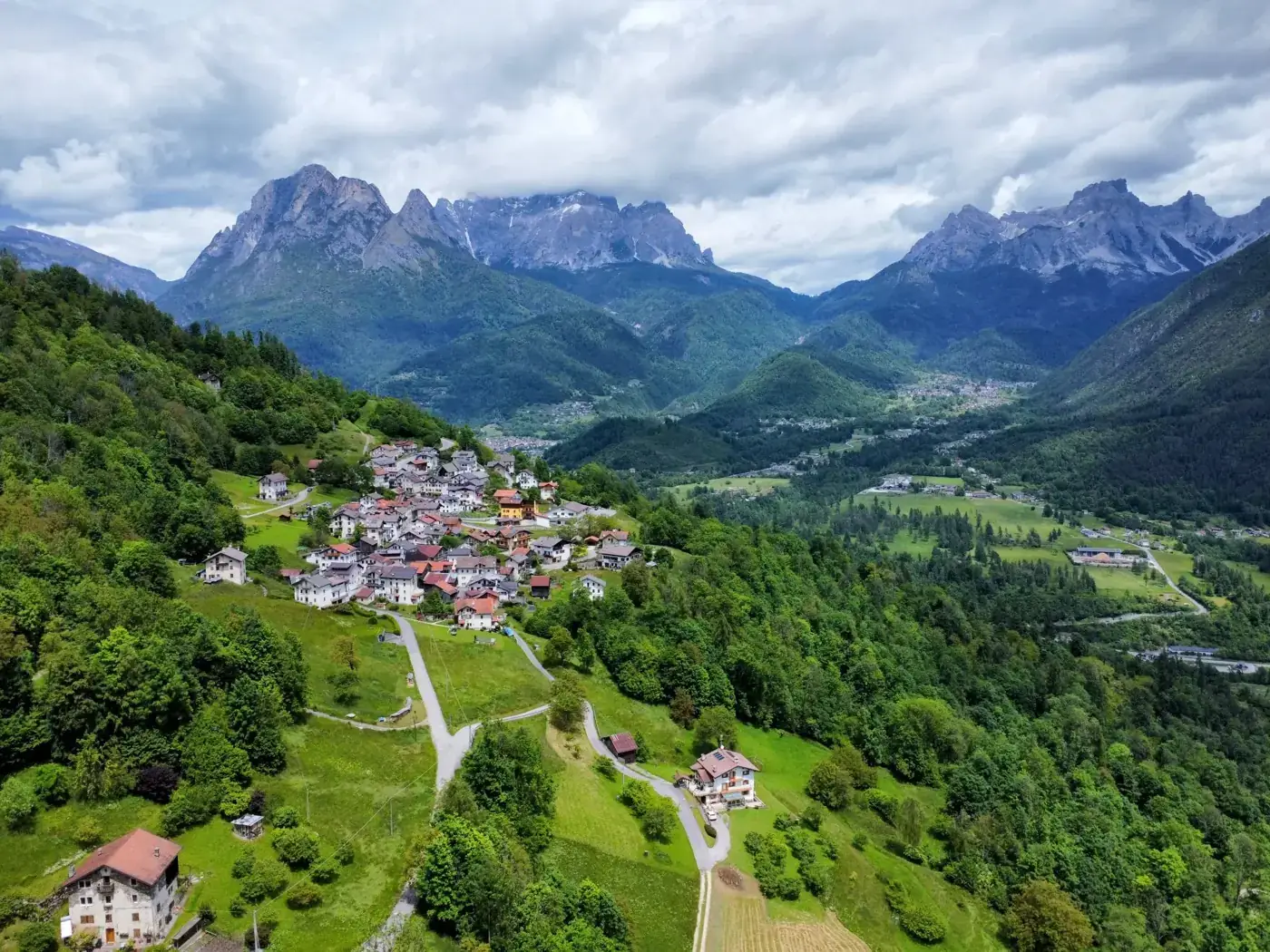 Stunning aerial shot of Agordo, Veneto featuring the Dolomites in the background.
