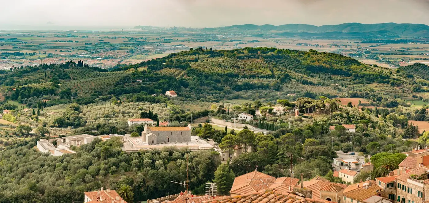 Aerial view of a picturesque countryside with lush hills and scattered houses.