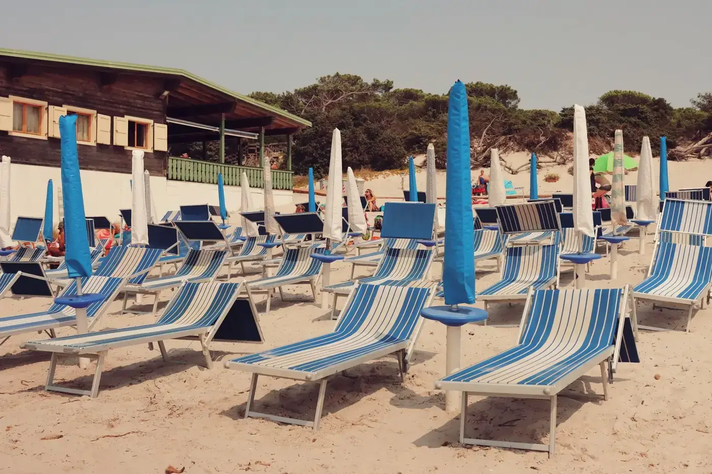 Empty deckchairs on a sandy beach at a seaside resort in Alghero, Sardinia.