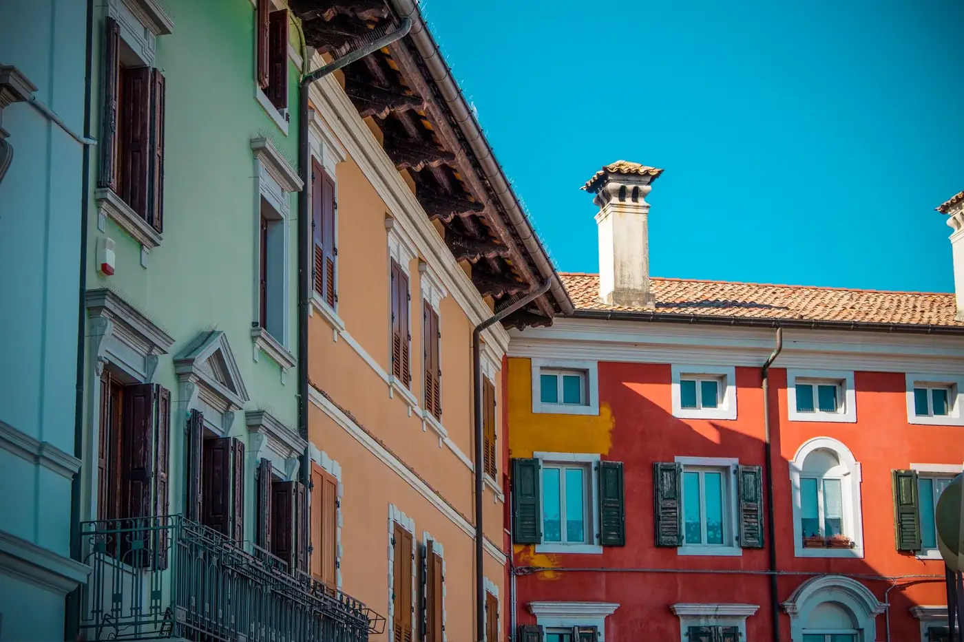 Vibrant historic buildings in Trieste, Italy, showcasing beautiful architecture under a clear blue sky.