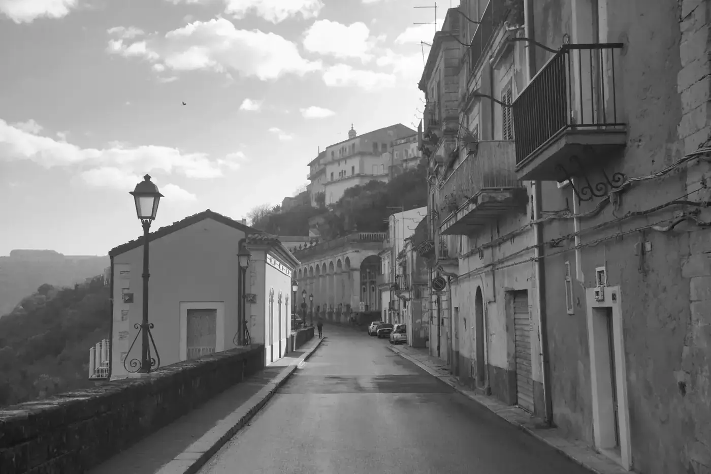 A picturesque street in Ragusa Ibla, showcasing classic Sicilian architecture in black and white.