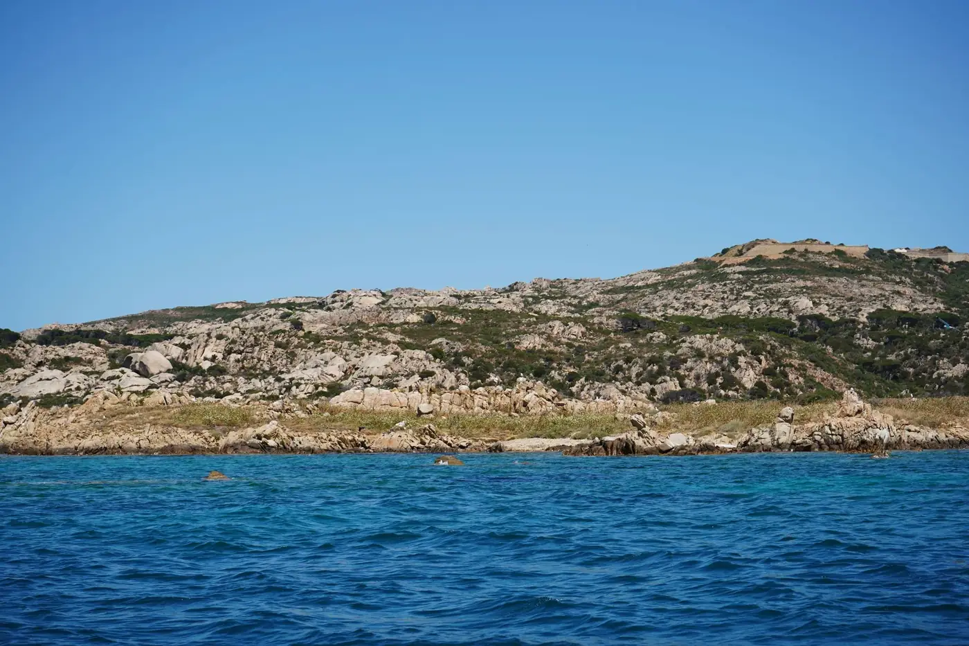 Beautiful view of rocky coastline and clear blue ocean in Sardinia, Italy.