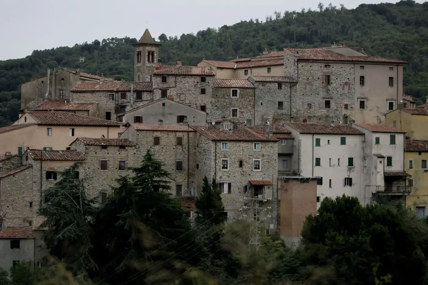 Charming view of a medieval Tuscany village nestled in lush hills.