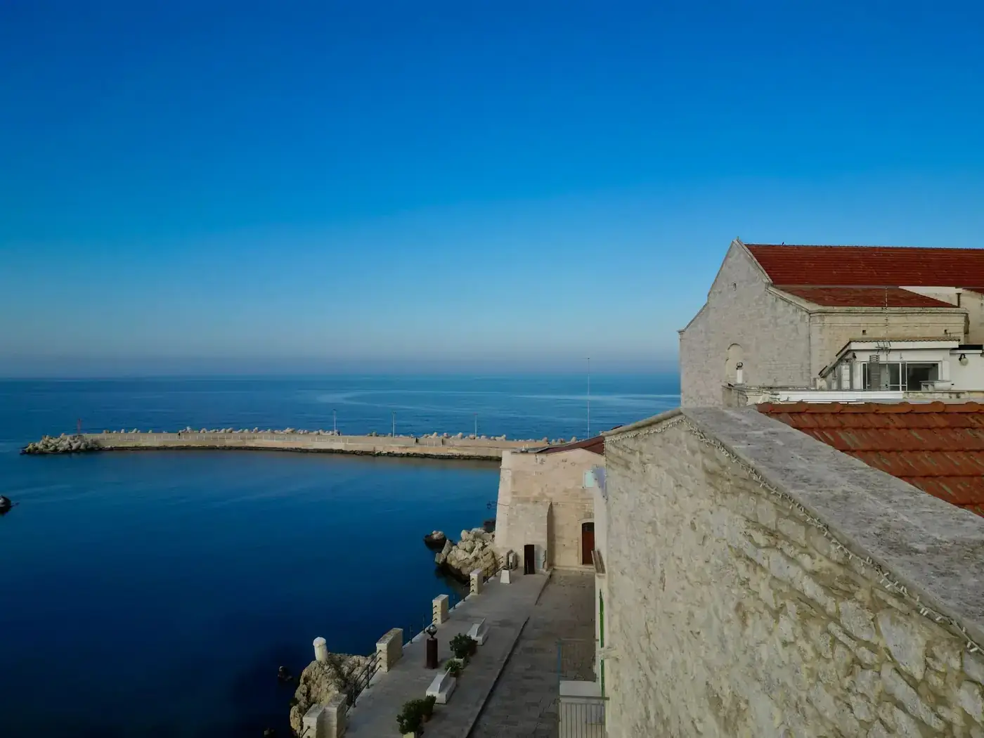 Idyllic view of Trani seaside with historic architecture and blue Adriatic sea.