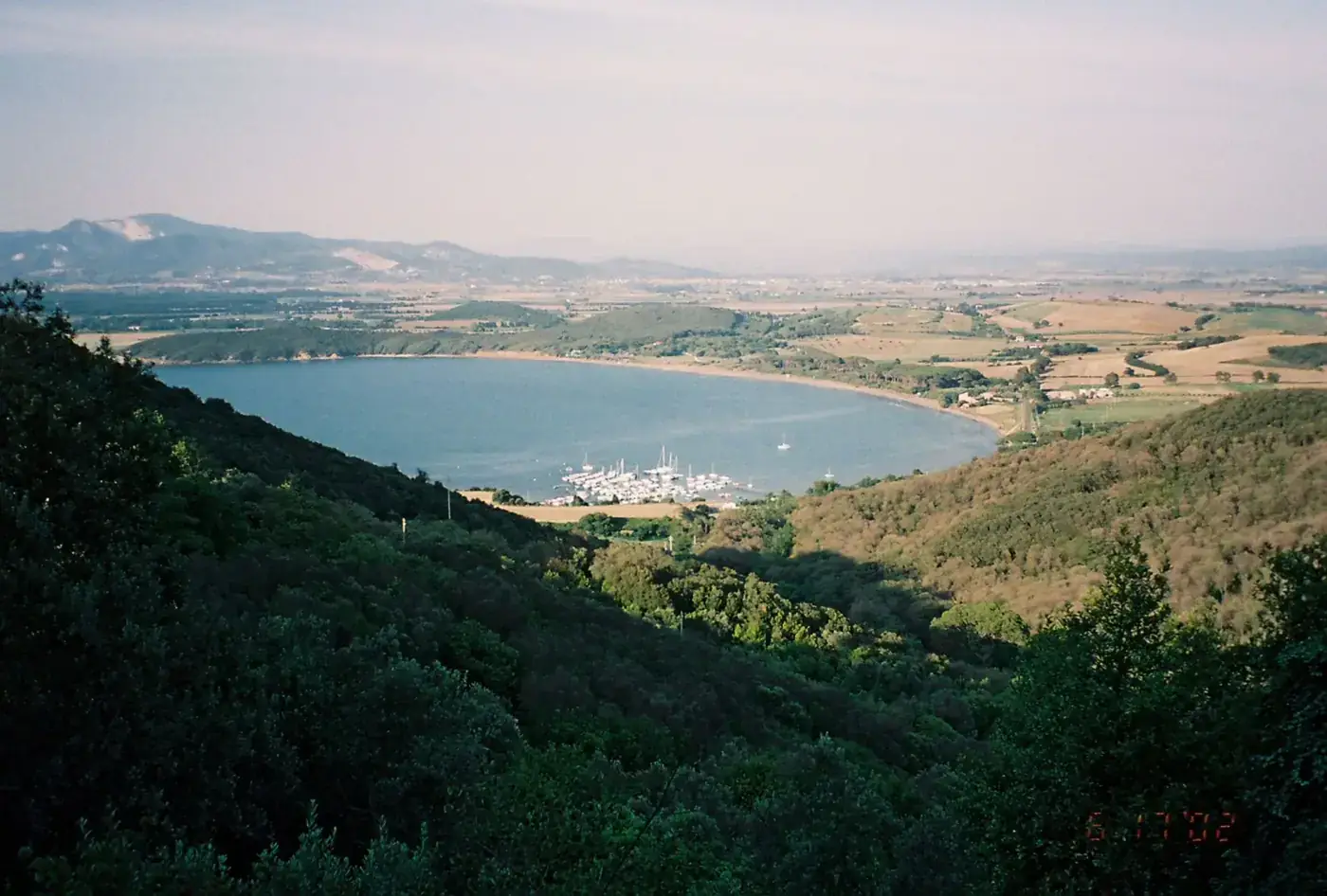 Panoramic view of Gulf of Baratti, Tuscany with lush greenery and coastal landscape.