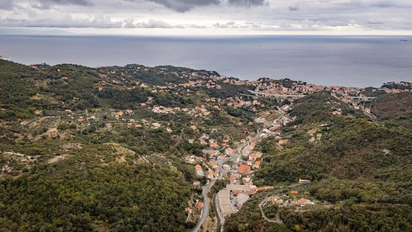 Breathtaking aerial view of Gameragna in Liguria, Italy surrounded by lush hills and overlooking the sea.