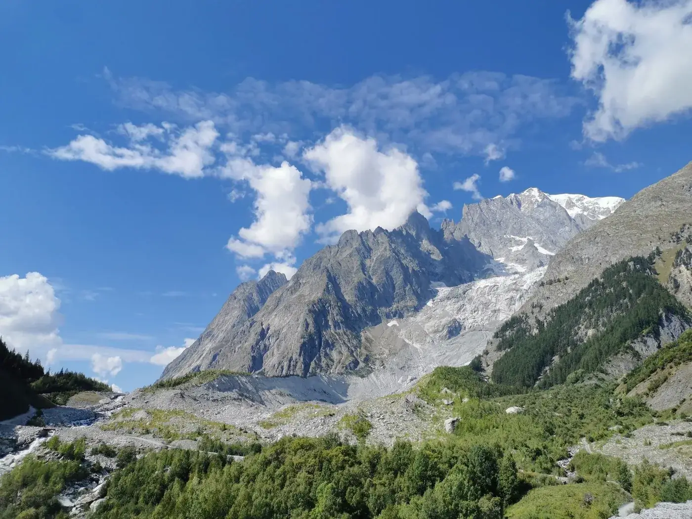 Breathtaking view of Mont Blanc from Aosta with clear blue skies and lush greenery.