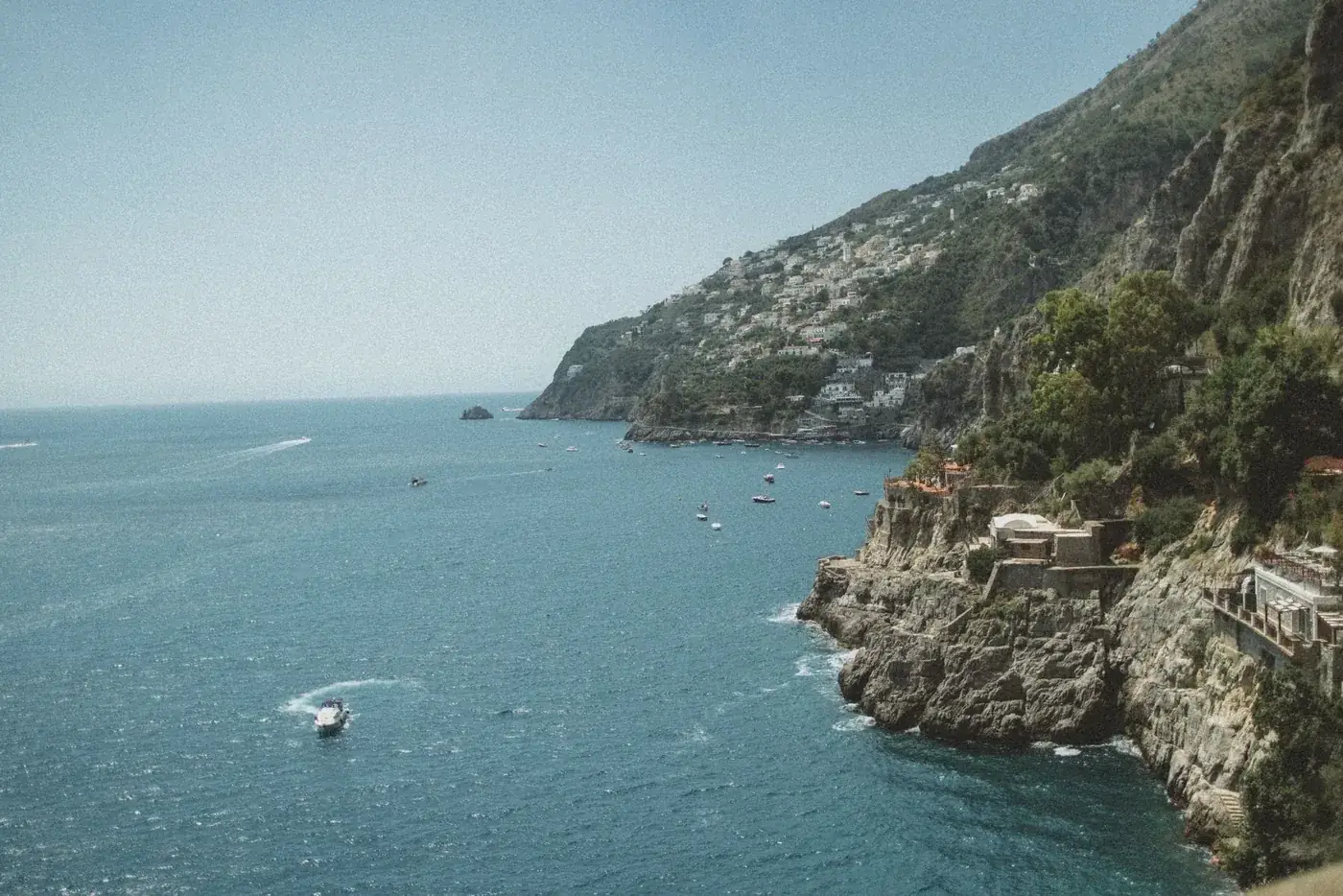 Stunning aerial view of Furore, Italy, showcasing the coastline and Tyrrhenian Sea under a clear blue sky.