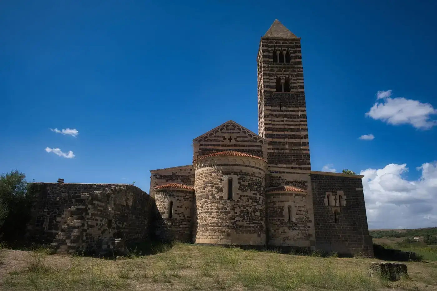 Captivating Romanesque church architecture amidst scenic Sardinian landscape.