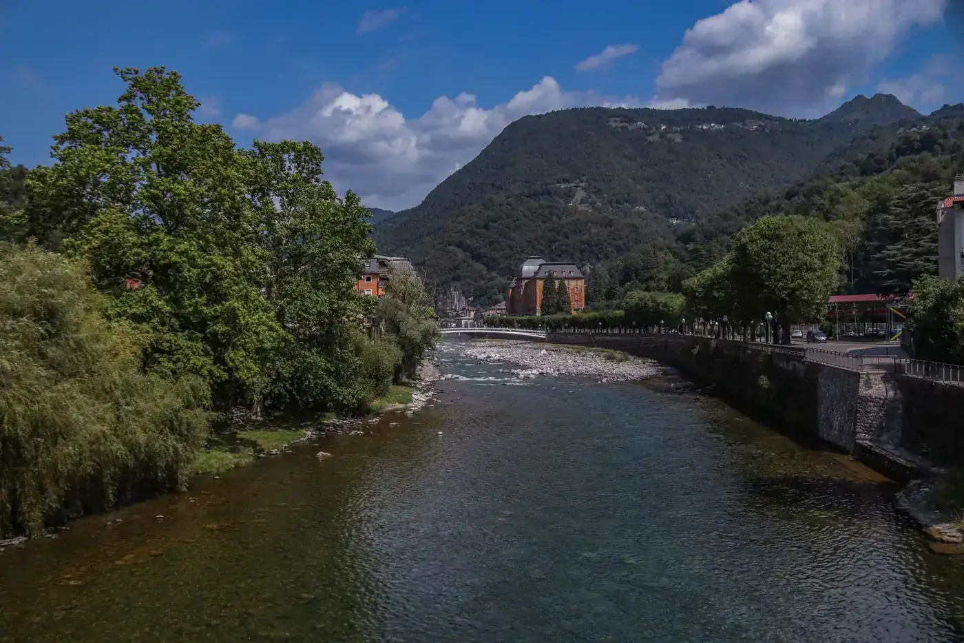 Picturesque river flowing through a serene mountain town with vibrant greenery.