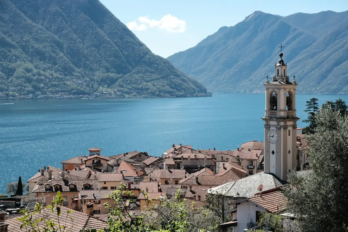 Stunning view of Lake Como from the village with a prominent bell tower against mountainous backdrop.