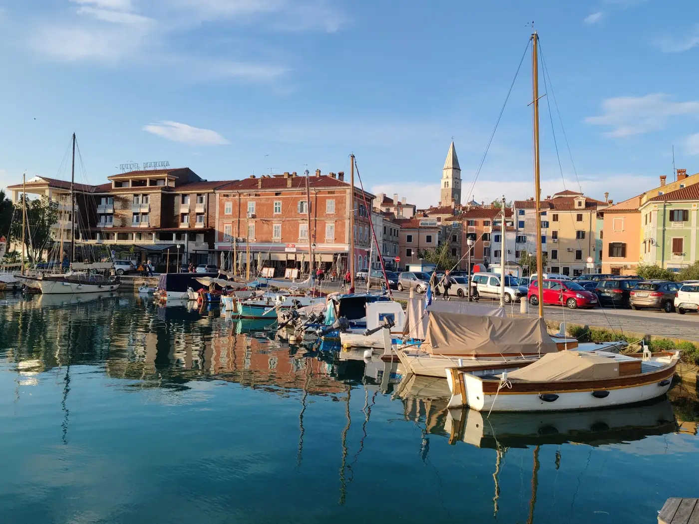 Beautiful harbor with boats and colorful buildings under blue sky.