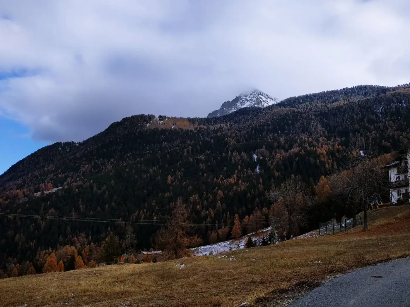 A scenic autumn view of a mountainous landscape in Valle d'Aosta, Italy with clear skies.