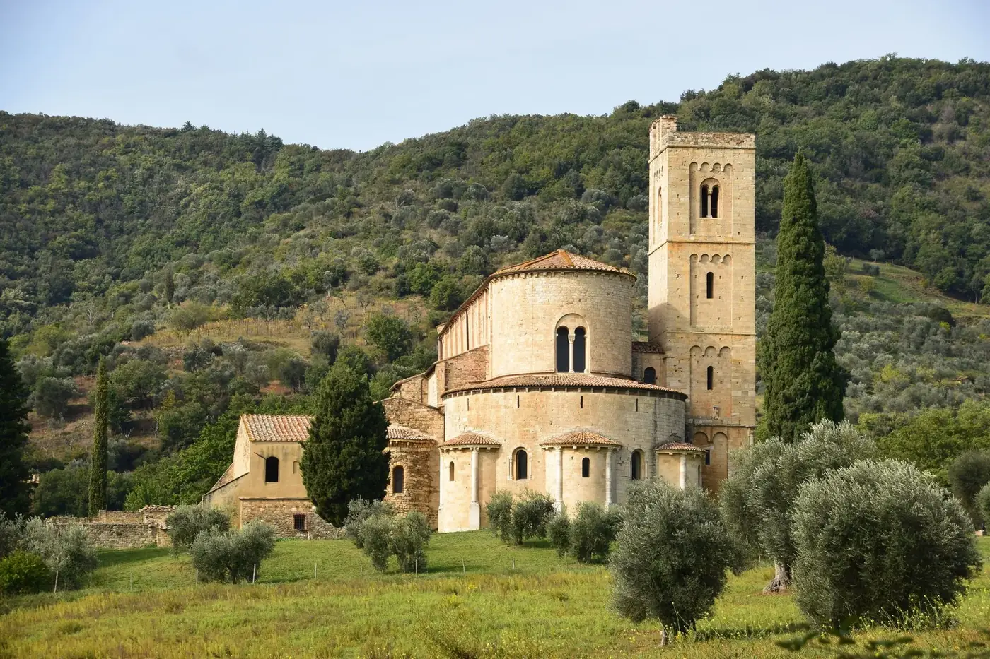 Beautiful view of Abbey of Sant'Antimo surrounded by lush greenery in Tuscany, Italy.