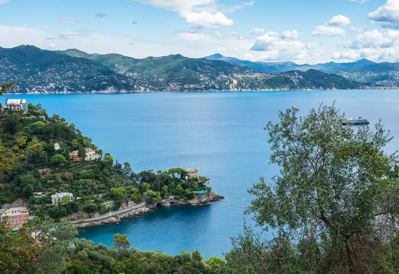 Breathtaking view of Liguria's coastline featuring lush greenery and tranquil waters.