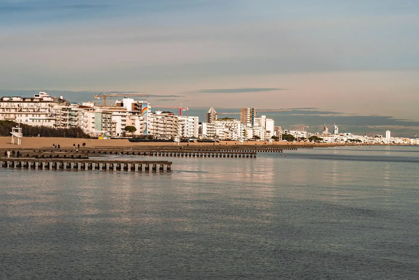 Tranquil evening view of urban coastline reflecting on calm sea waters.