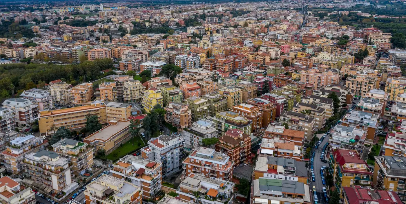 Picturesque drone view of colorful residential buildings and streets with automobiles located near small green park