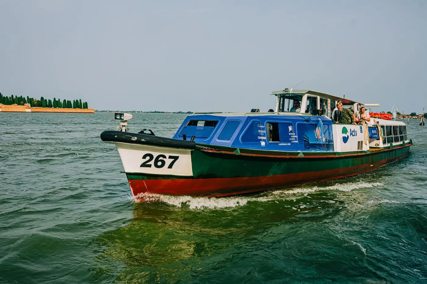 Passenger ferry boat navigating through the Venetian Lagoon on a clear day.