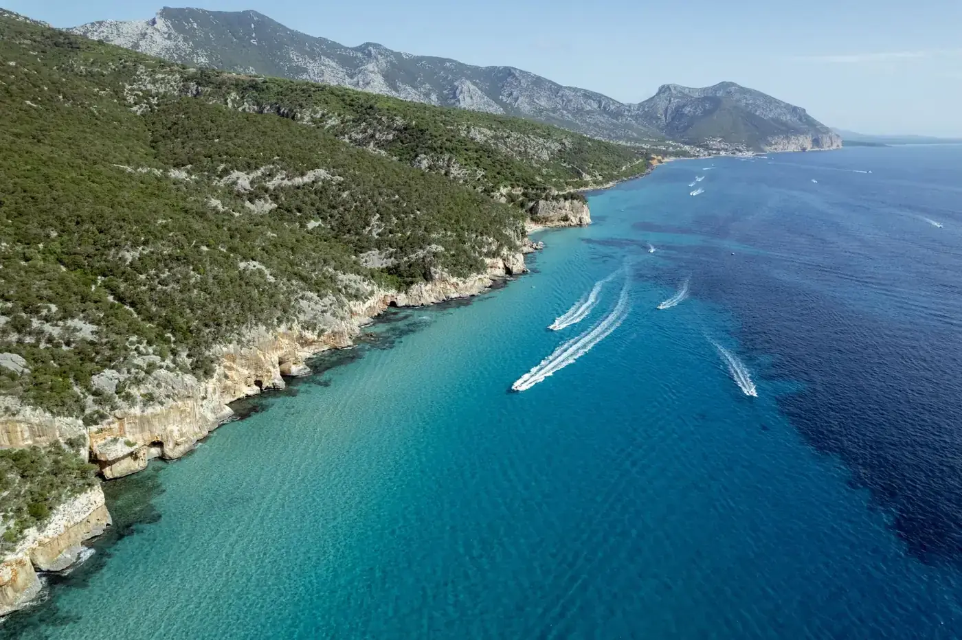 Explore the stunning cliffs and azure waters of Sardinia's coastline from a breathtaking aerial perspective.