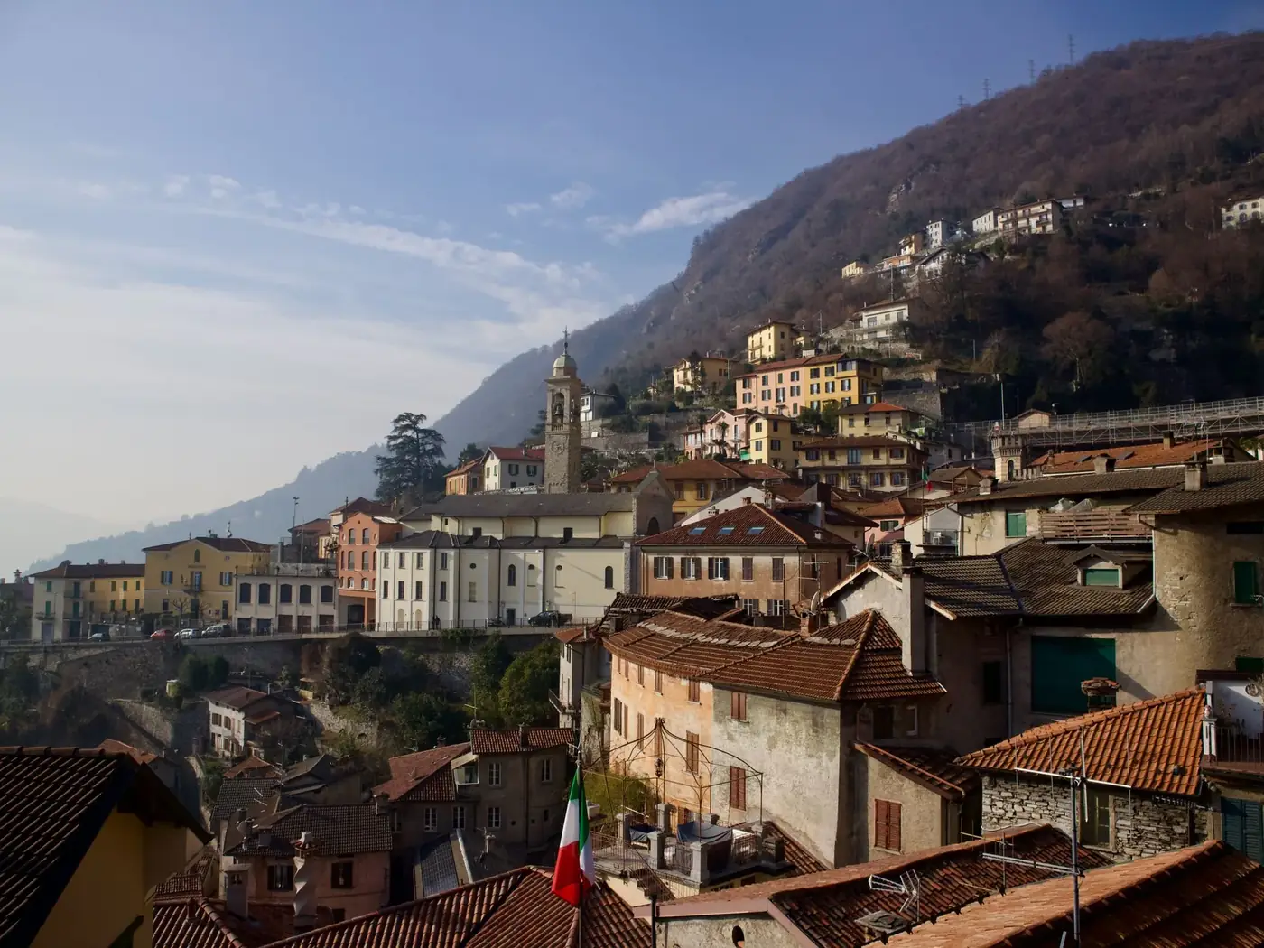 Picturesque hillside village in Italy with traditional houses and church, captured during daytime.