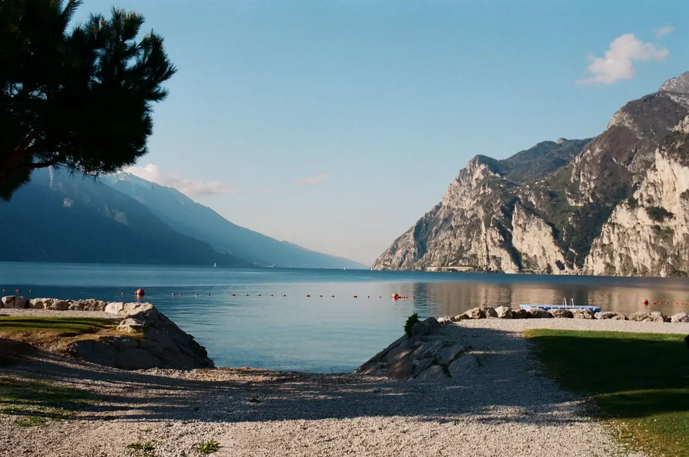 Spectacular scenery of calm sea bay rippling near rough stiff mountains and sandy shores under cloudless sky on sunny we