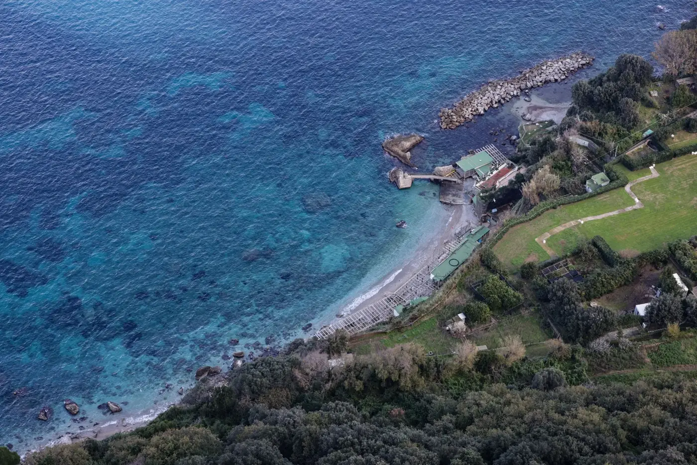 A tranquil aerial shot of Capri's coastline showcasing azure waters and lush greenery.