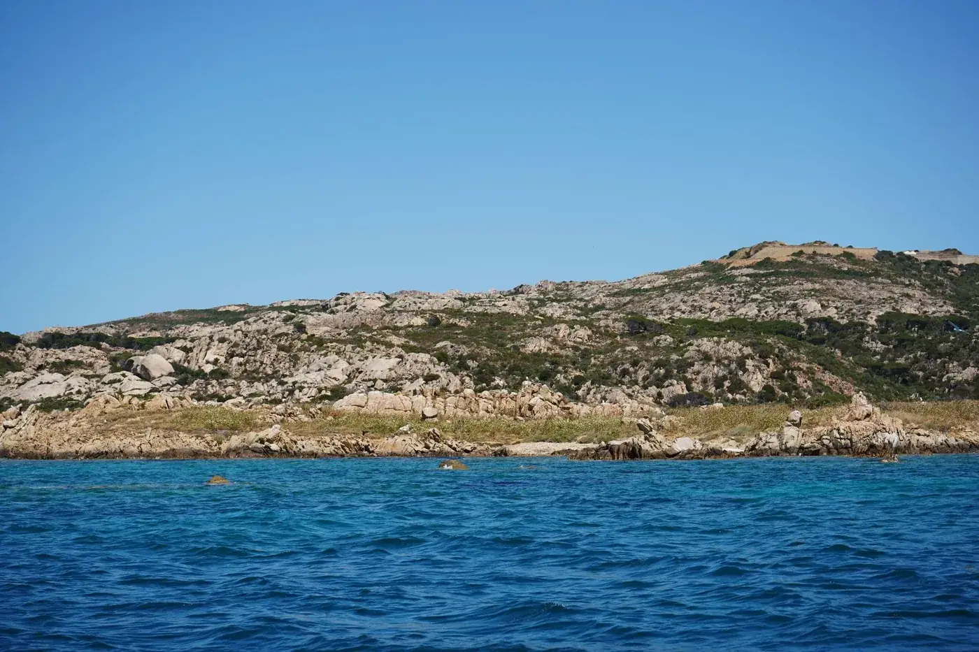 Beautiful view of rocky coastline and clear blue ocean in Sardinia, Italy.