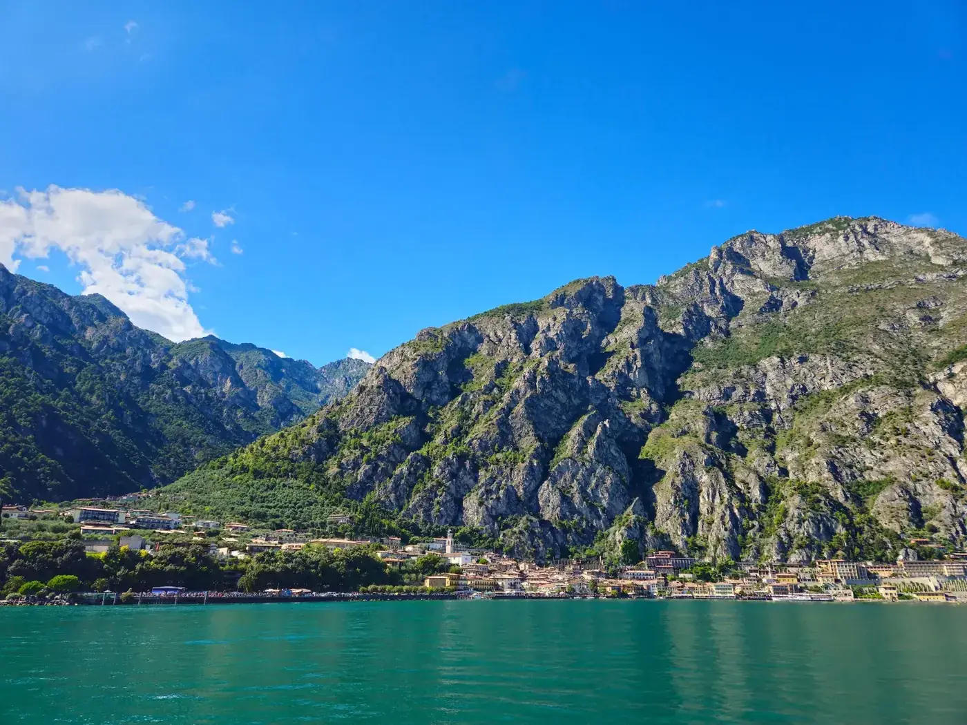 Stunning landscape of Limone sul Garda with mountains and lake under a clear blue sky.