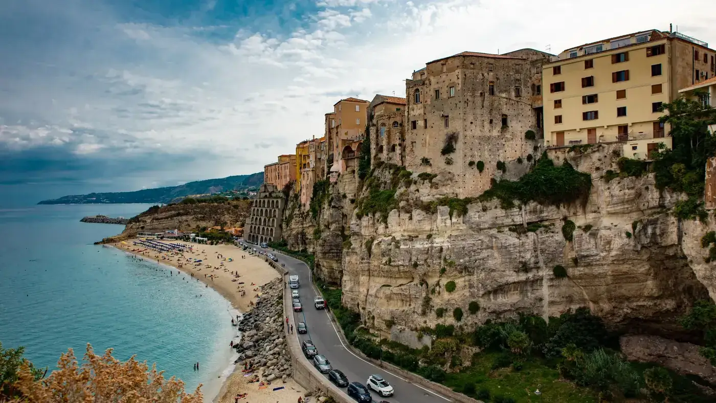Picturesque old town on a cliff by the coast, showcasing historic architecture and a scenic beach.