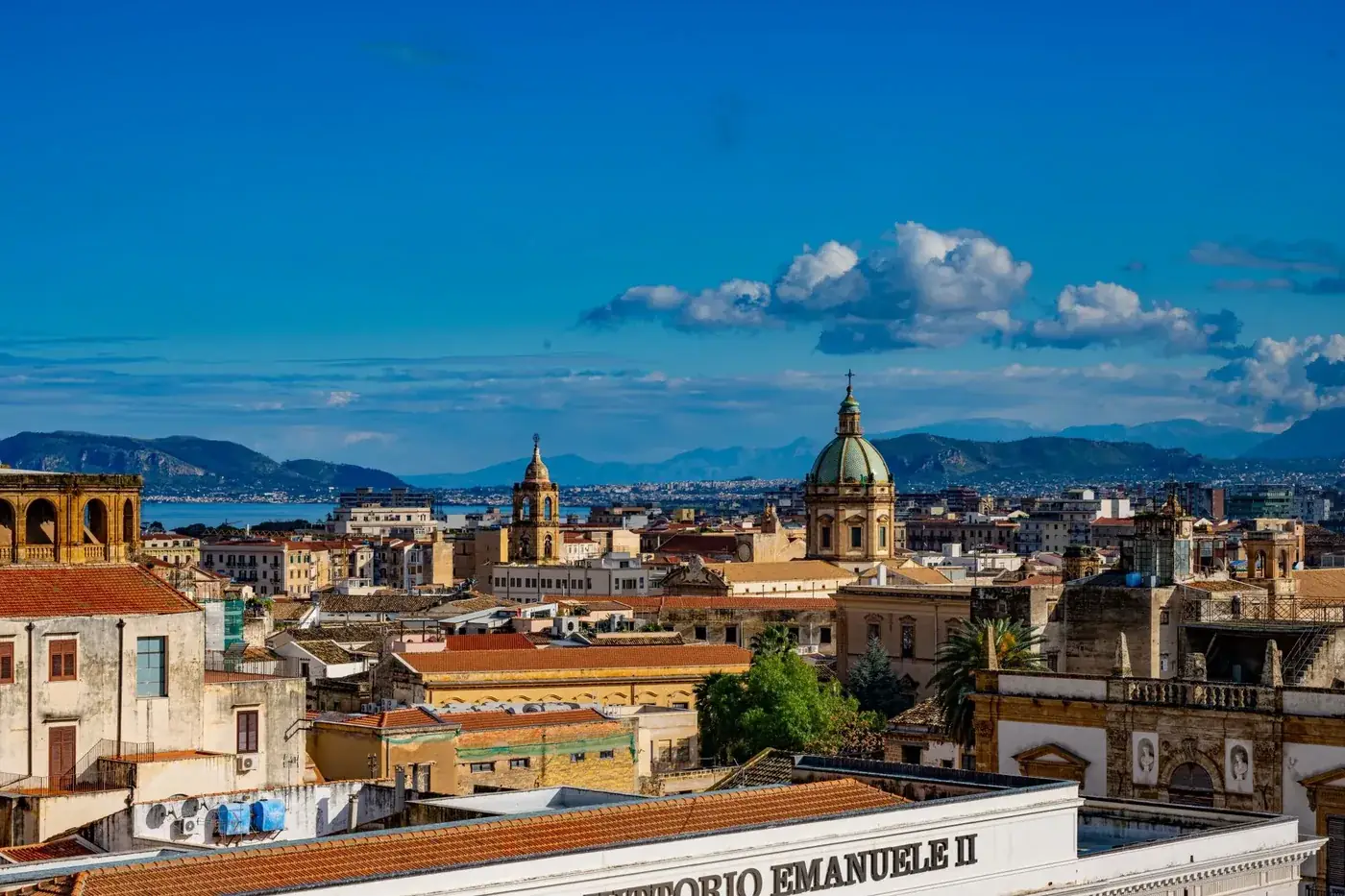 Discover the vibrant skyline of Palermo, Sicily capturing historic architecture beneath a bright blue sky.