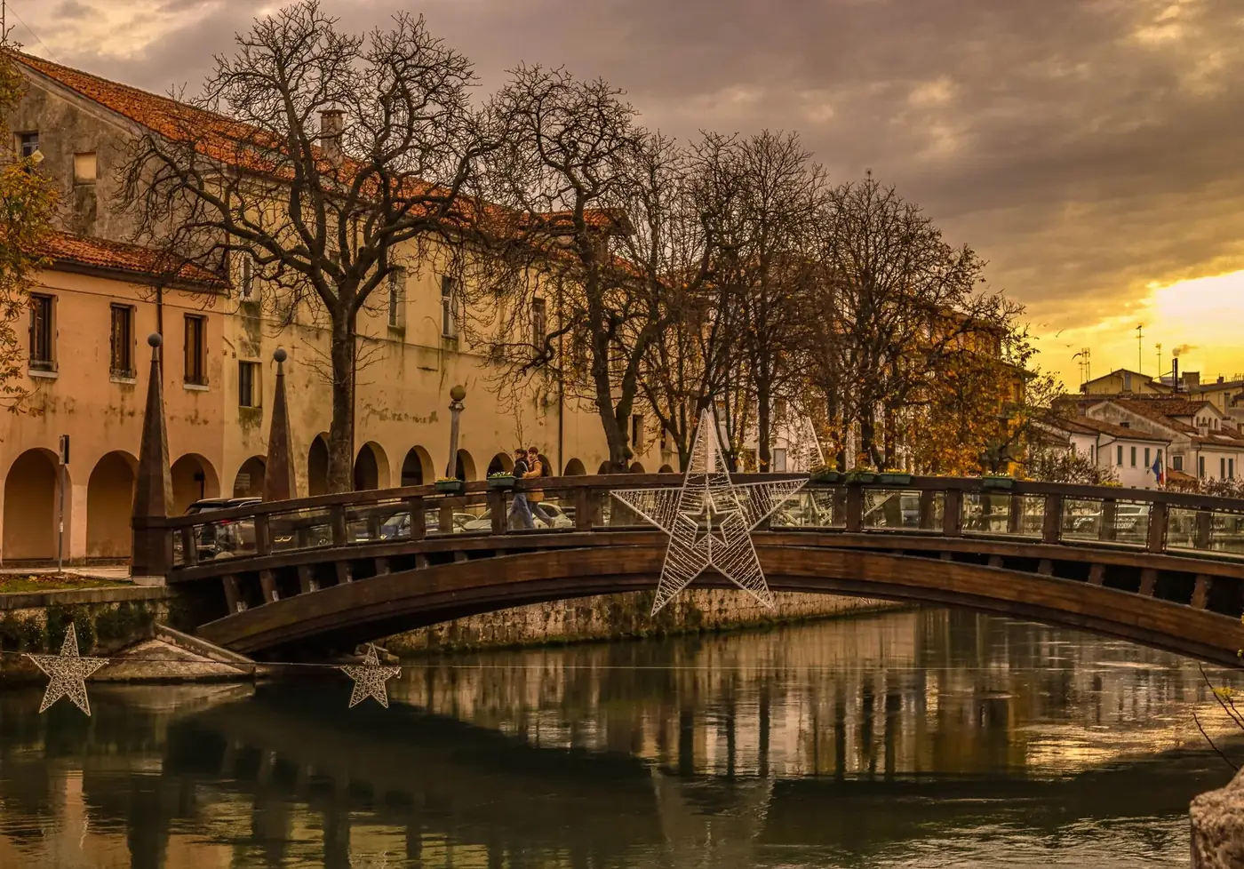 Charming view of a historical bridge adorned with stars during winter sunset.