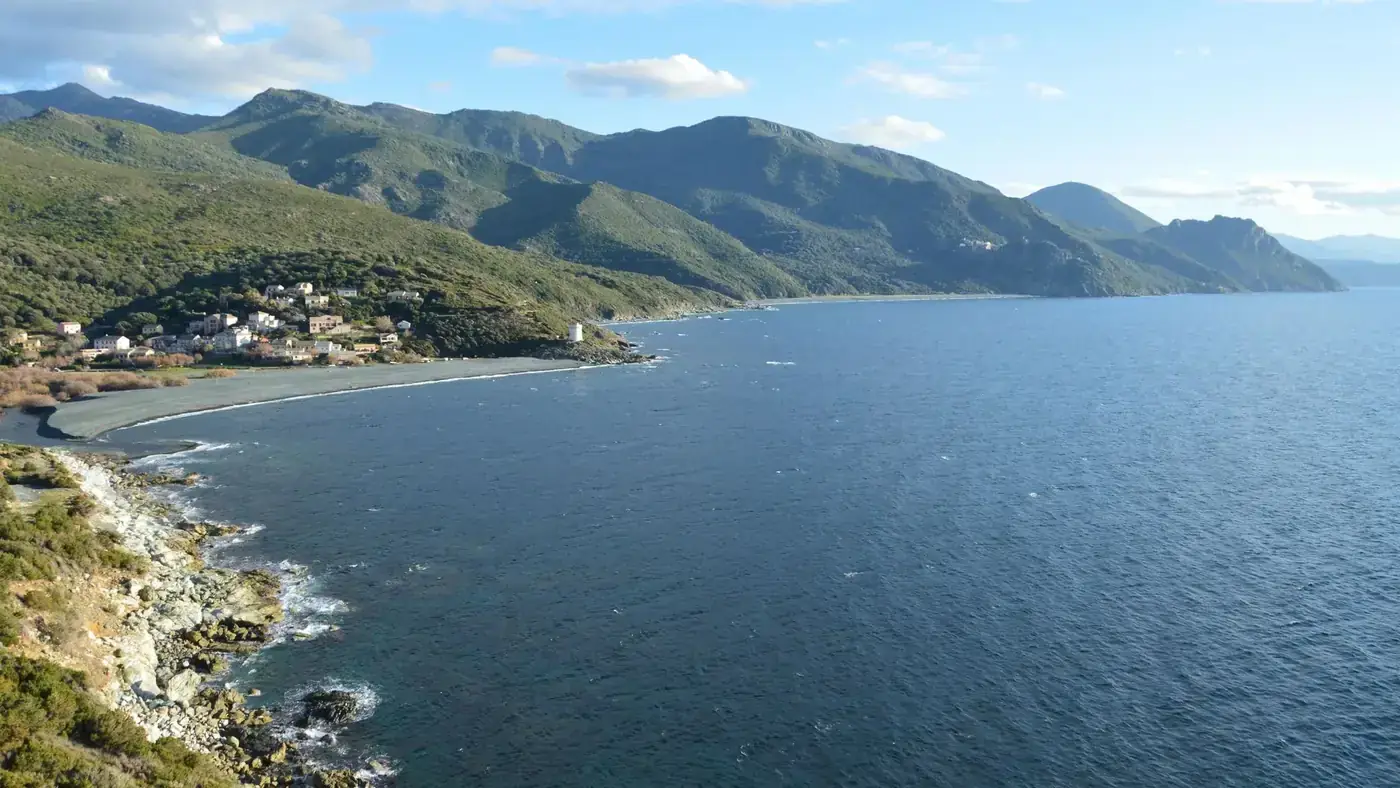 Beautiful aerial view of Ogliastro's coastline in Corse, France, featuring the lush mountains and blue sea.
