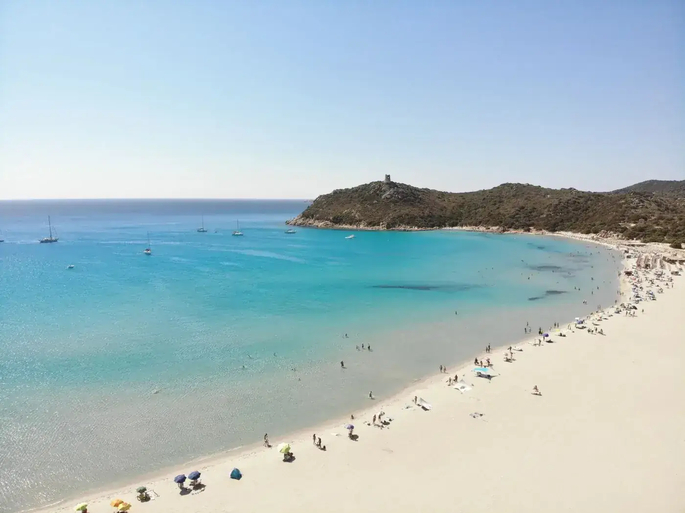 Drone shot capturing the vibrant turquoise waters and pristine beaches of Sardegna, Italy, full of life.