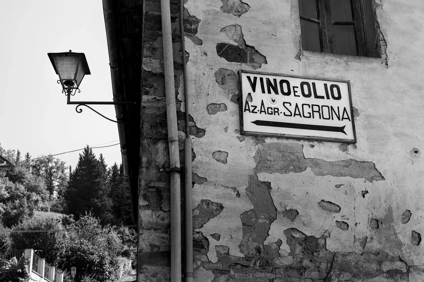 Rustic exterior with antique lamp and sign in Tuscany village.