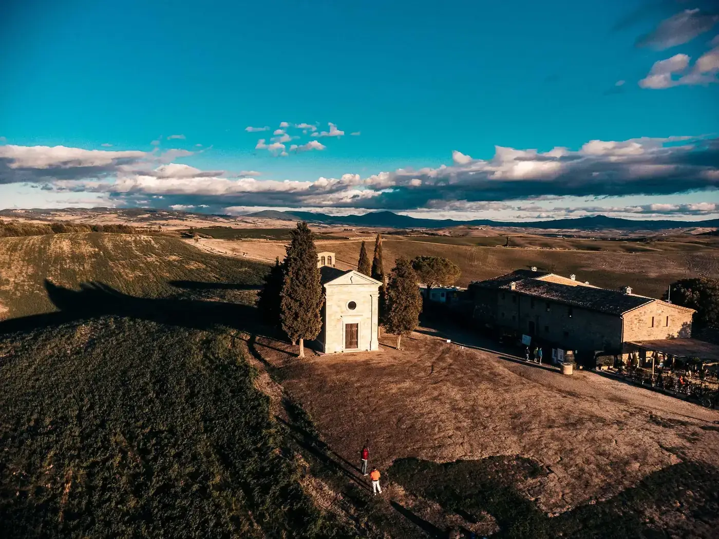 Aerial view of Chapel della Madonna di Vitaleta surrounded by Tuscan landscape in San Quirico d'Orcia, Italy.
