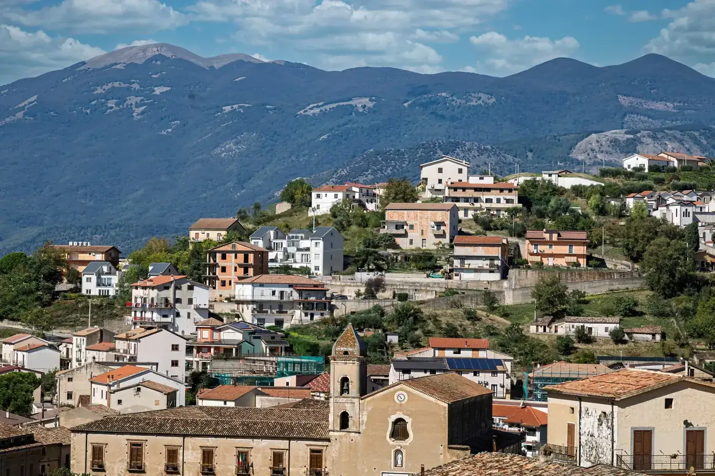 A picturesque village in Villapiana, Italy, set against lush mountains.