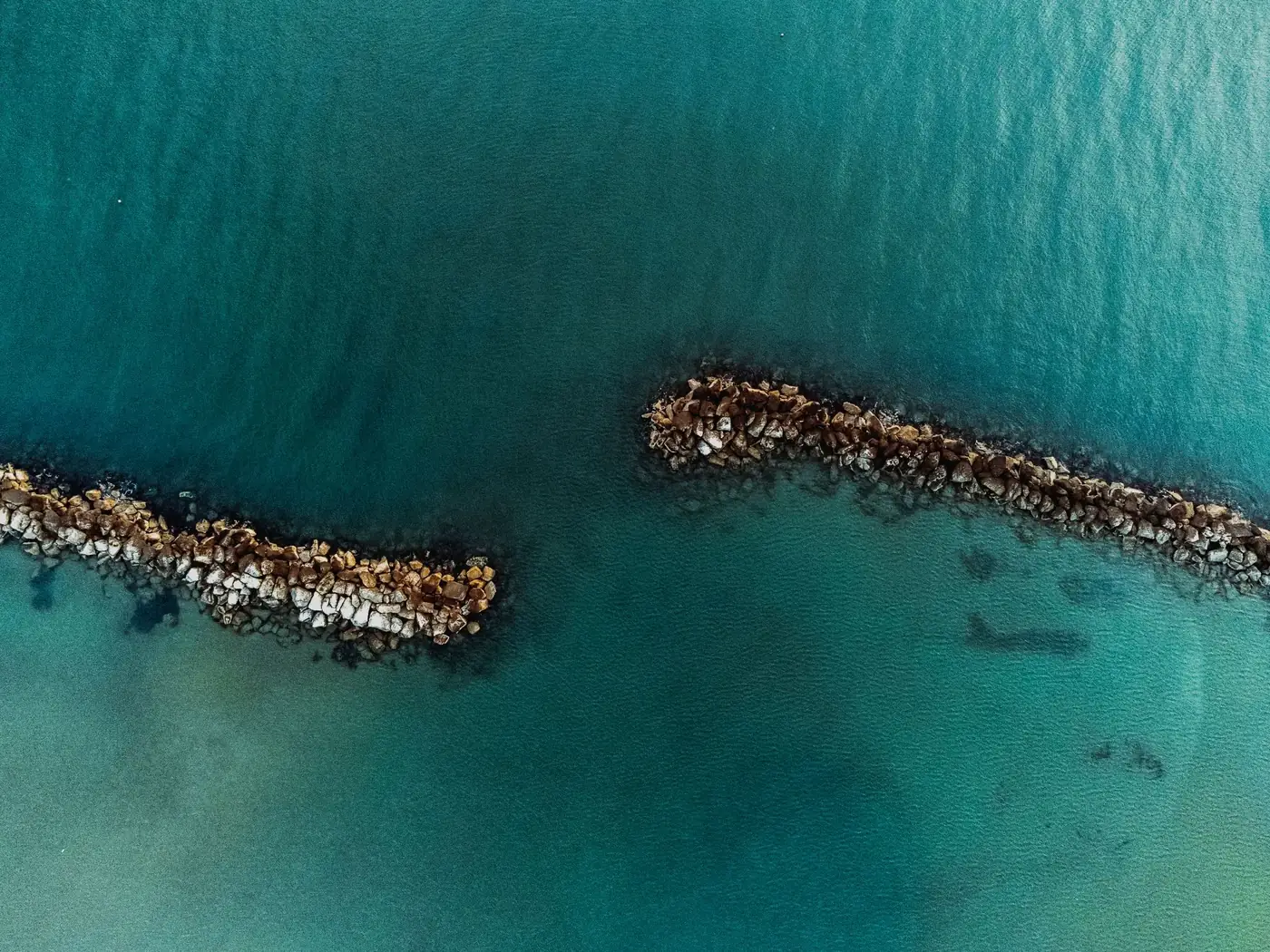 Aerial shot showcasing the beautiful coastal rocks and clear sea of Igea Marina, Italy.